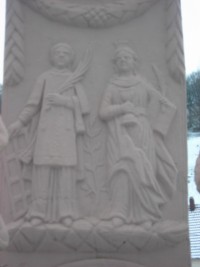 Saint Laurent et sainte Barbe sont représentés sur le fût.
