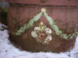 Un cœur enflammé occupe le centre du socle de la croix.