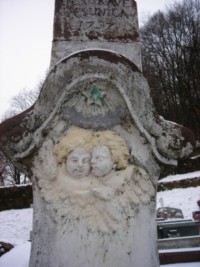 Deux têtes d'angelots ailées, ainsi qu'une étoile, occupent le registre supérieur du fût.