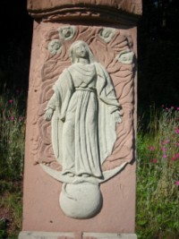L'Immaculée Conception de la Très Sainte Vierge est représentée sur le fût de la croix.