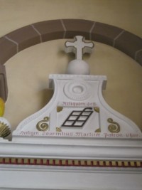 L'autel est surmonté du grill accompagné de l'inscription : « Reliquien des Heiligen Laurentius, Martirer Patron v. hier ».