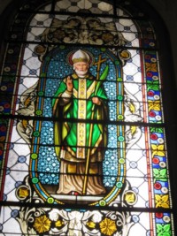 Un vitrail représente un saint évêque.