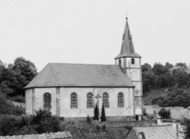 Une croix de mission est adossée à la façade Nord de l'église, remployant le socle et le fût d'une croix de cimetière du XIXe siècle (photographie du service régional de l'inventaire de Lorraine).