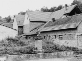 La fontaine Saint-Jean-Baptiste se situe dans la rue de l'école, à Lengelsheim. La statue du saint a été remplacée par celle de saint Laurent, patron de la paroisse (photographie du service régional de l'inventaire de Lorraine).