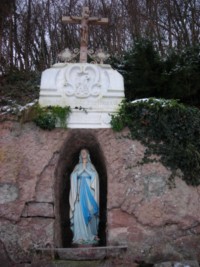 La statue de l'Immaculée Conception domine la grotte de Lourdes.