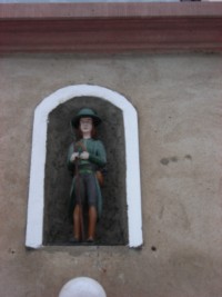 Une statuette de saint Wendelin trône dans une niche au-dessus d'une porte de maison, dans la rue principale de Lengelsheim.