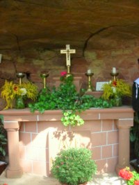 Un autel de grès rose est installé à l'intérieur de la grotte. Un autel de grès rose est installé à l'intérieur de la grotte.