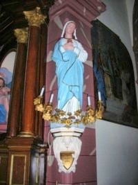 Une statue du Cœur Immaculé de Marie est située à gauche de l'arc triomphal de l'église de Rolbing.
