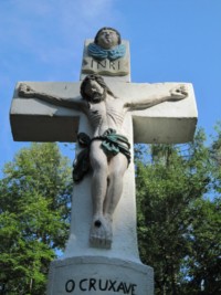 Le croisillon est dominé par une tête d'angelot ailée.