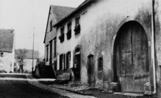 La rue de Bitche au début du XXe siècle, en contrebas de l'église : la maison d'œuvres à gauche et la maison d'Antoine Meyer à droite.