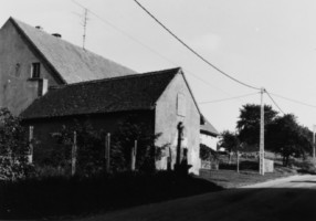 La croix est adossée à la maison numéro 31, dans la rue principale du hameau d'Eschviller.