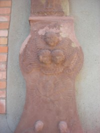 Trois têtes d'angeloits ailées sont représentées au centre du fût de la croix du hameau d'Eschviller, devant la maison numéro 7 rue principale.