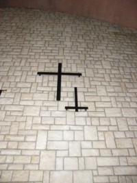 Une croix murale est installée contre le mur du chœur.