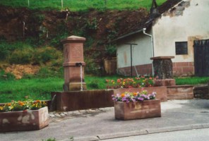 La fontaine du village (photographie de la com. de com. du pays de Volmunster).