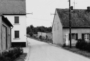 Une croix monumentale est située dans la rue de la forêt.