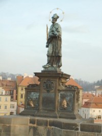Une statue monumentale de saint Jean Népomucène, datant de 1683, est érigée sur le pont Charles ou Karlsbrücke de Prague, lieu de son martyre (image provenant de Wikimedia Commons).
